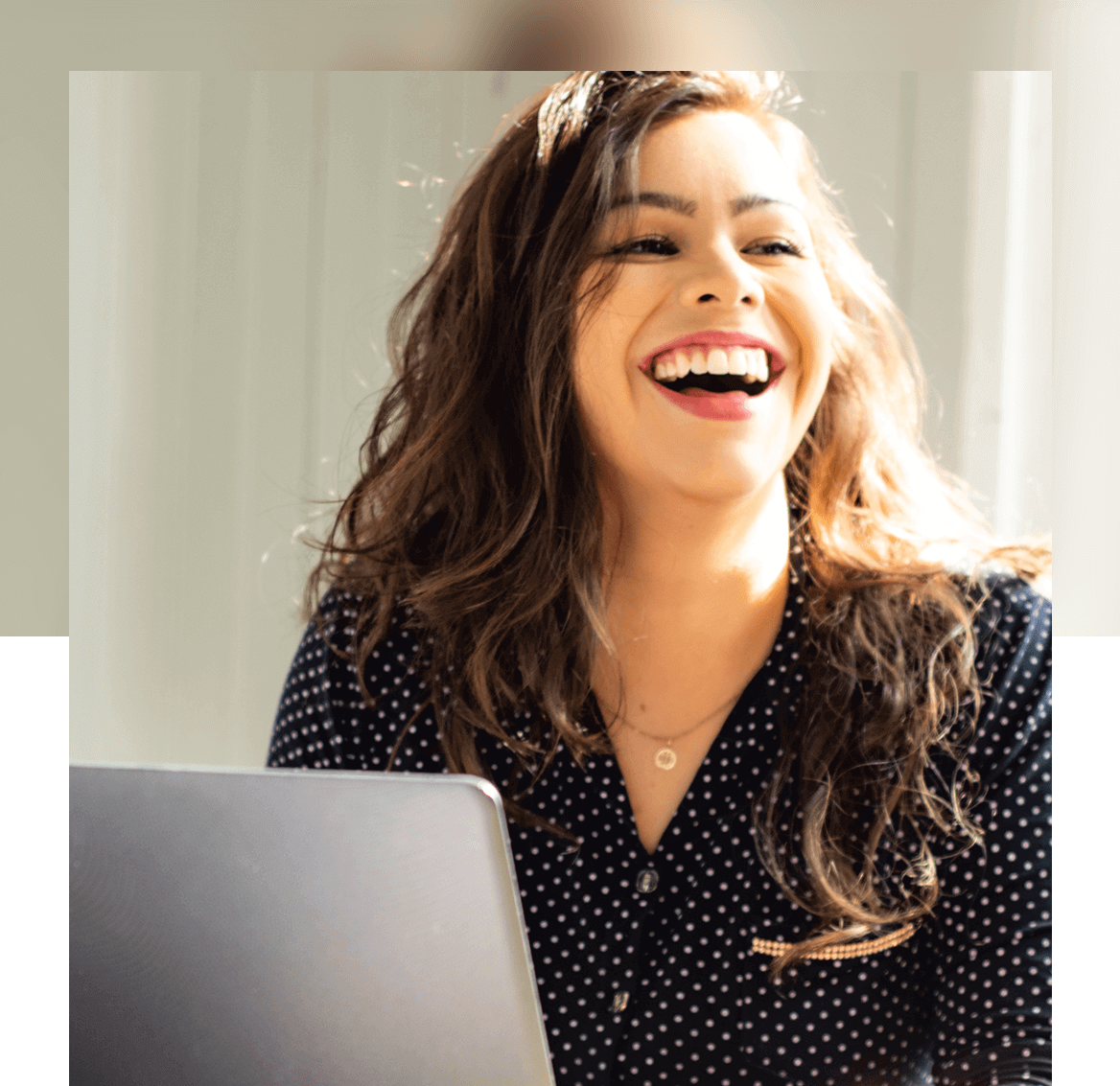 Woman smiling while working on laptop
