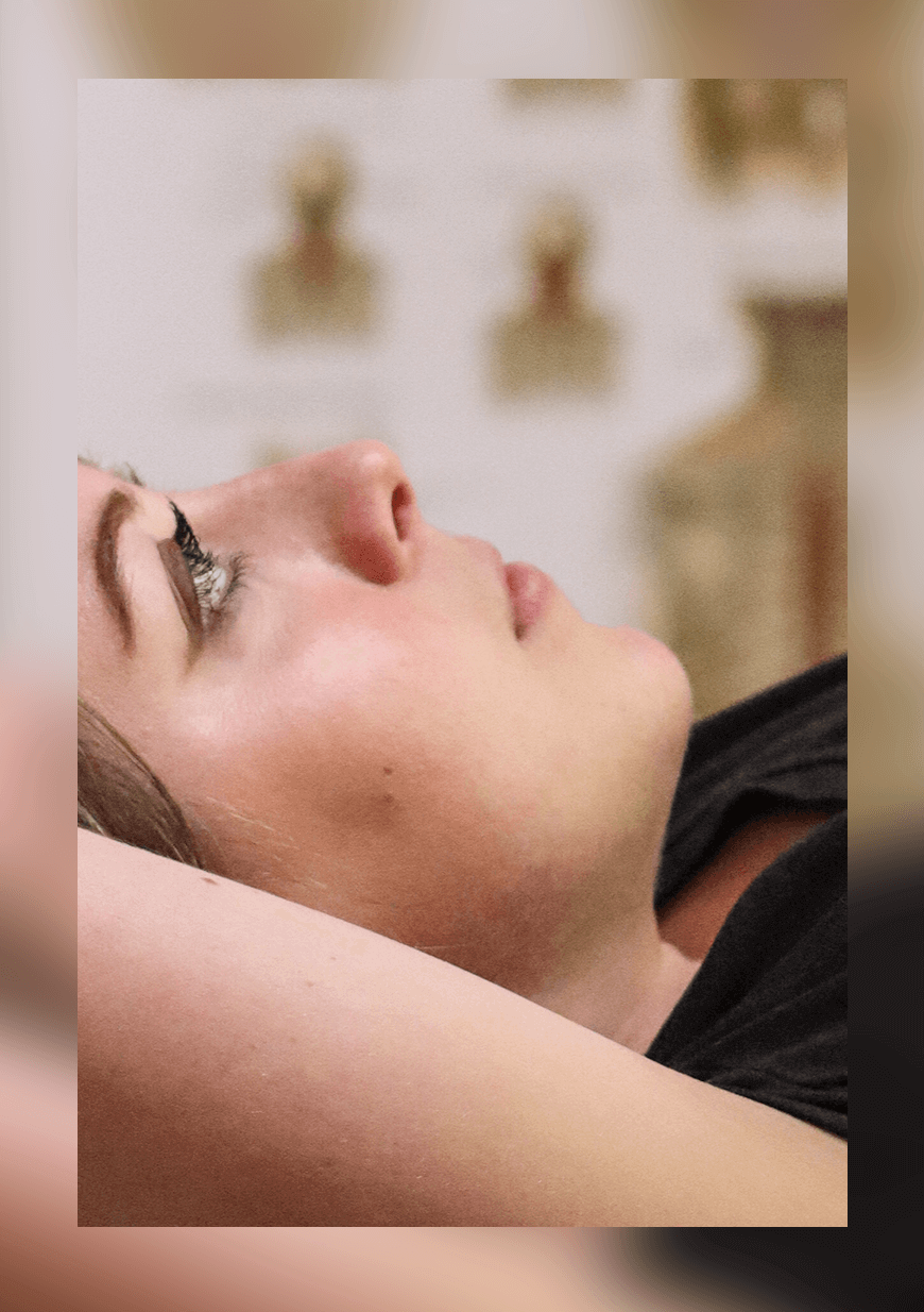 Woman stares upwards while lying down